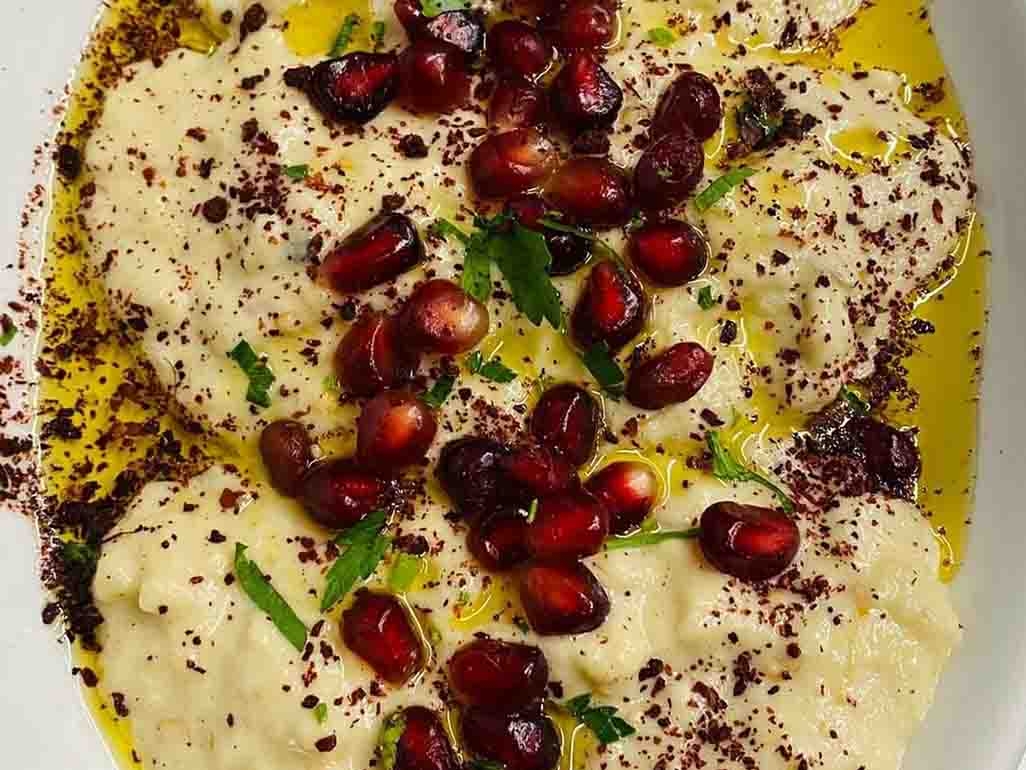 Hummus with olive oil, pomegranate seeds and coriander