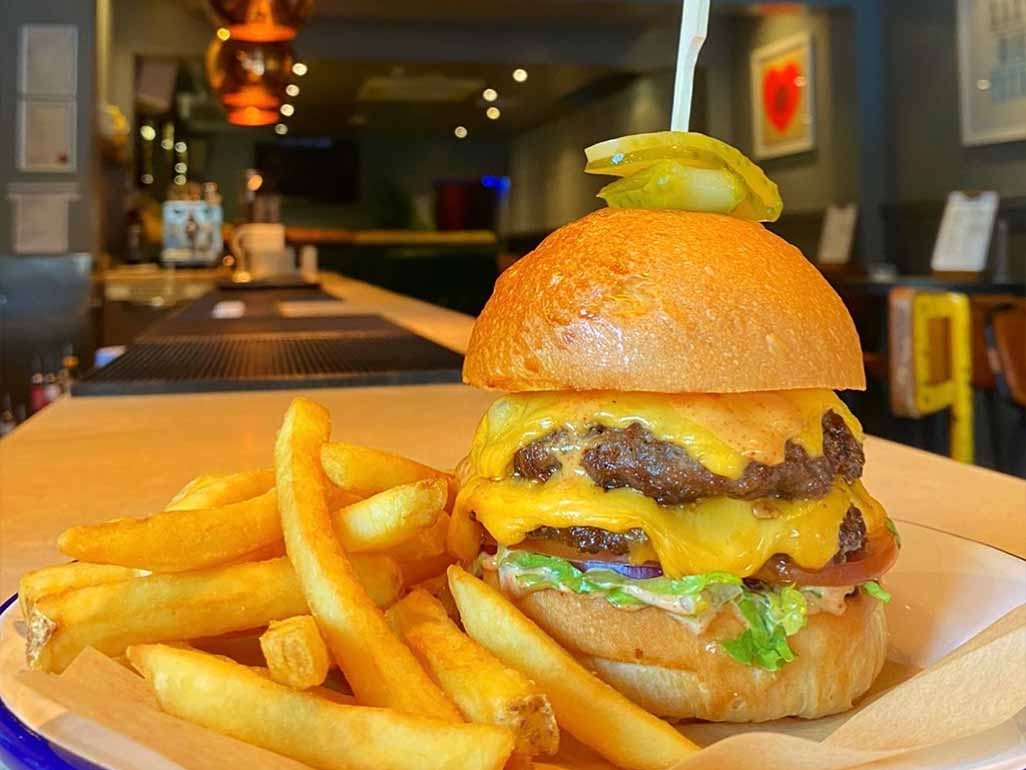 Double beef, cheese burger with gherkins and fries